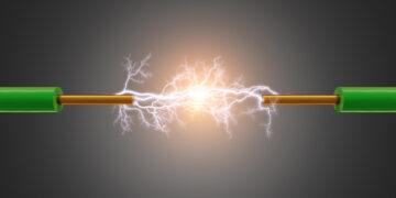 Schematyczne przedstawienie przepływu elektronów w metalowym przewodniku, symbolizujące prąd elektryczny.